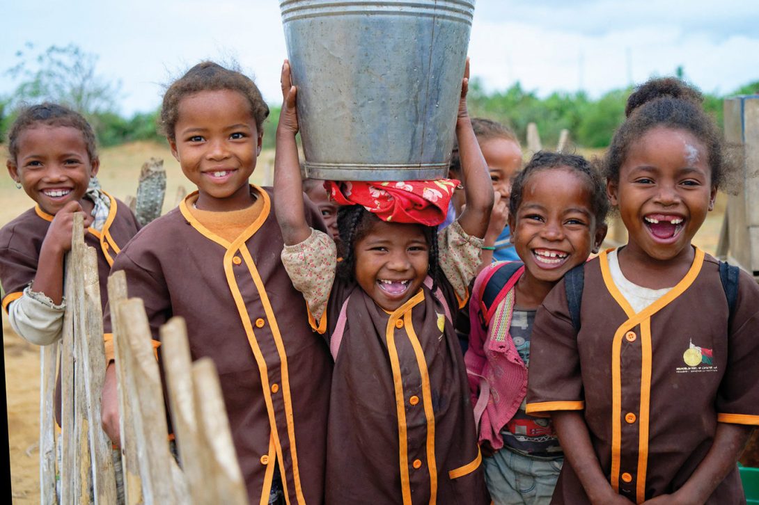 October 16, 2024 : Terabovo Primary Public School, Commune of Sihanamaro, Ambovombe District, Androy Region, Madagascar : group photo of smiling schoolgirls coming to collect water from the school's standpipe. The school is one of the beneficiaries of Zonta International funding. UNICEF's WASH program contributes to reducing vulnerability and strengthening the resilience of local communities, with a particular focus on young girls and adolescents to promote their empowerment. In this regard, and in line with the objectives of the Ministry of Water, Sanitation, and Hygiene, UNICEF views menstrual hygiene and health management as a human right and as one of the key entry points for having both direct and indirect influence on self-esteem, mental health, physical health, and socio-economic well-being, ensuring the overall well-being of individuals. This 24-month funding from Zonta International supports the implementation of an environmentally sensitive WASH program in schools. To achieve this goal, UNICEF plans to train 750 school teachers in environmental conservation, including the WASH component. Additionally, to actively engage children and adolescents in environmental and climate change initiatives from a young age, five pilot schools in the same districts will be targeted with climate-related activities such as tree planting, the introduction of school gardens, the creation of greenhouse nurseries, sustainable waste management, and the construction of improved, resilient sanitation and hygiene infrastructure, such as basic latrines equipped with handwashing stations. Special attention will be given to the specific needs of young girls and adolescents to adequately manage hygiene during menstruation through the sexual and reproductive health and rights program.